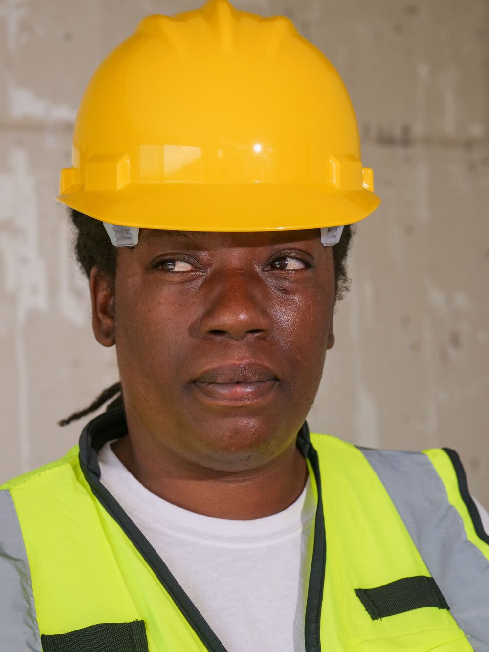 A site manager in a yellow hard hat and high-vis vest